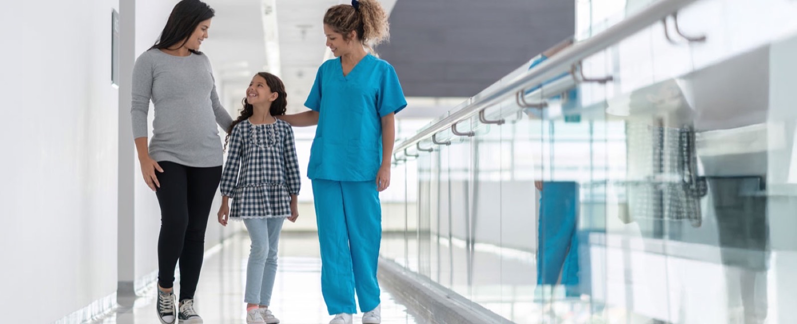 A mother, child, and doctor visiting in a hospital