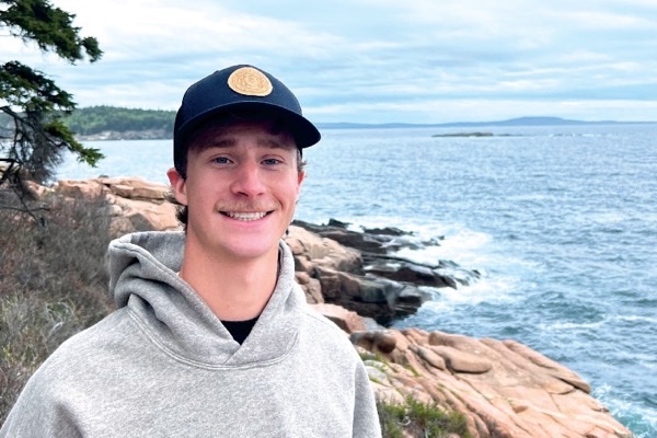 Luke Garner standing on a rocky ocean coastline